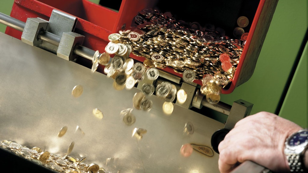 Swiss franc pieces falling out of a machine