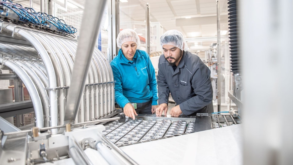 Механик, работающий над деталью машины.