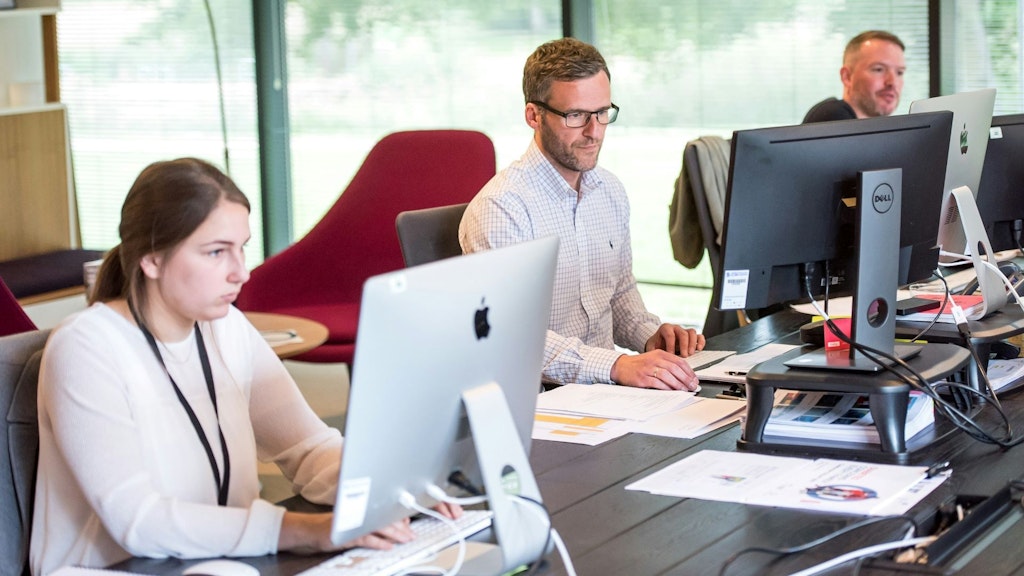 Personen arbeiten im Büro vor dem Bildschirm