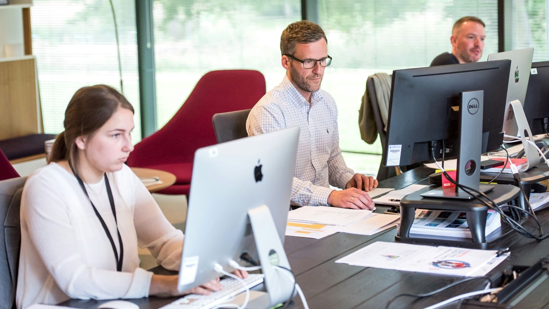 Personen arbeiten im Büro vor dem Bildschirm