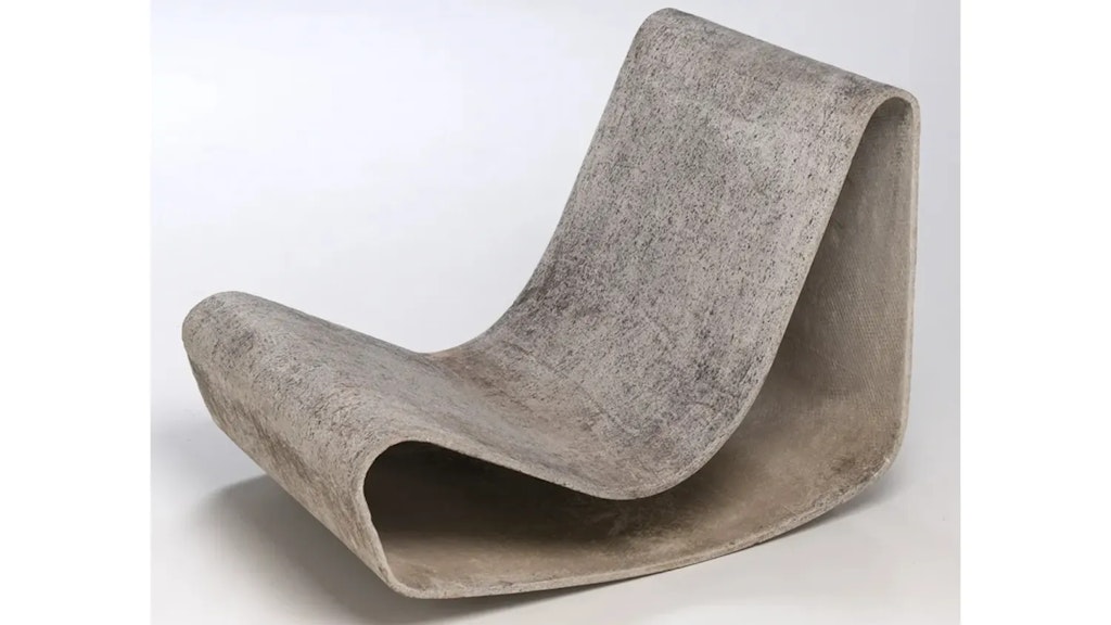 Liegestuhl aus Faserzement, in einem Stück geformt, mit welliger Form, auf weissem Hintergrund stehend.