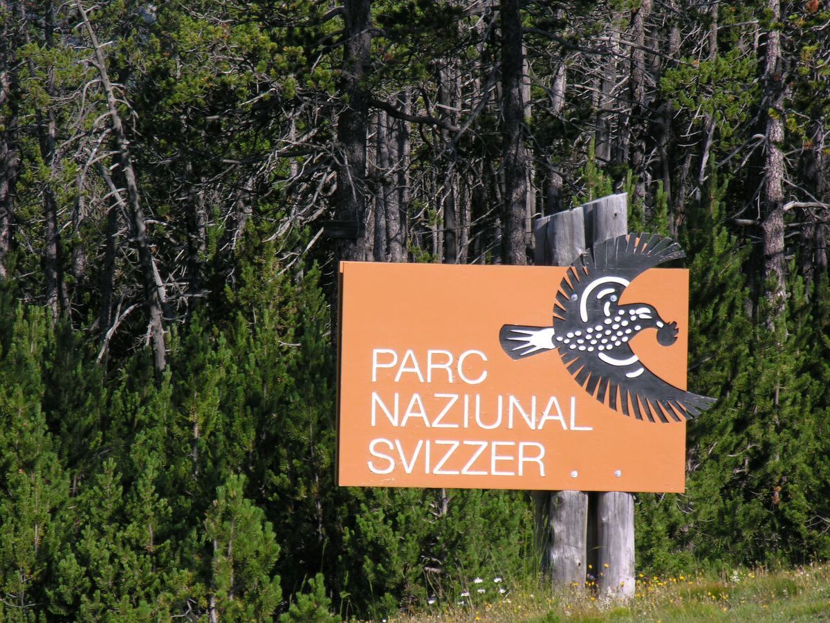 Ein Schild in rätoromanischer Sprache weist auf den Schweizerischen Nationalpark hin, der im Kanton Graubünden liegt.