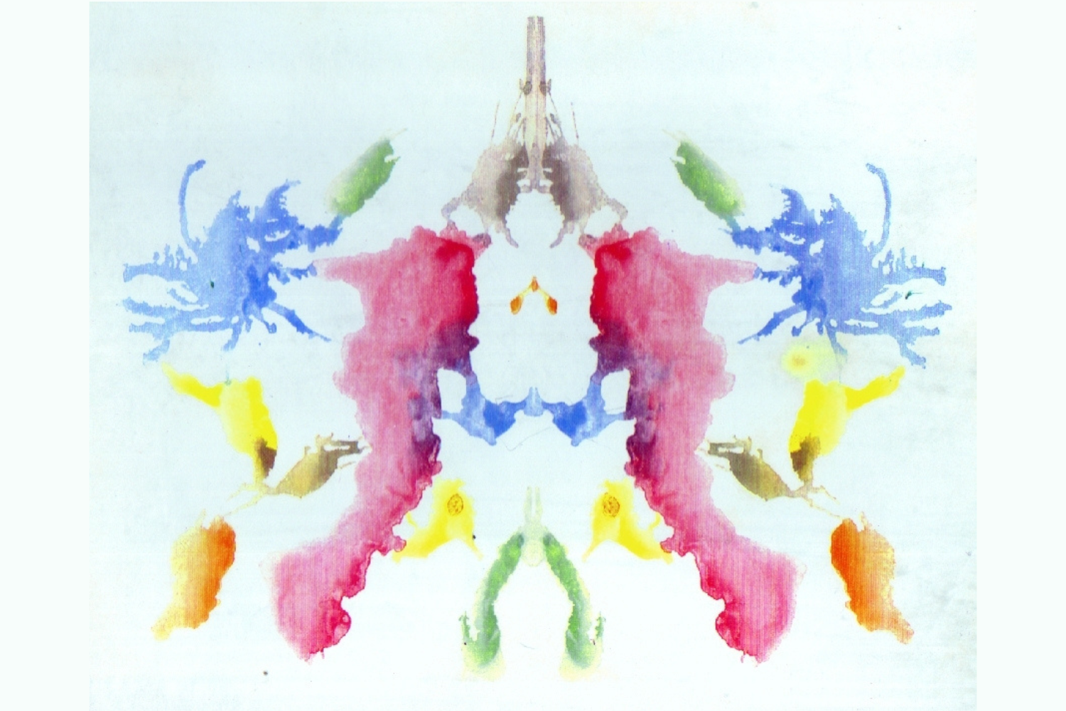 Symmetrical multicoloured inkblot on white background featuring a central red vertical shape flanked by blue, yellow and green forms on either side.