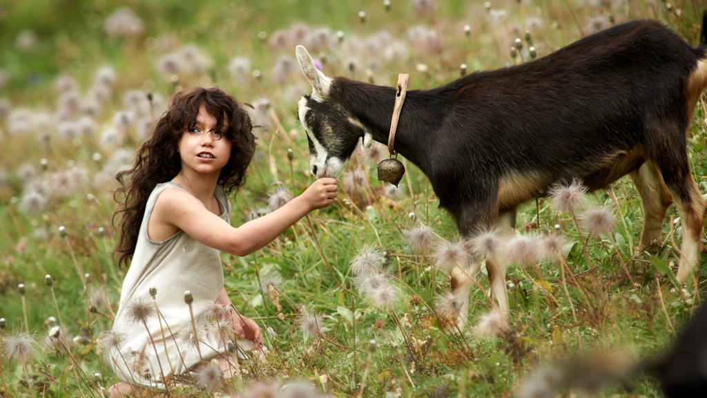 Film clip: Heidi on a flower meadow in the mountains with a goat.