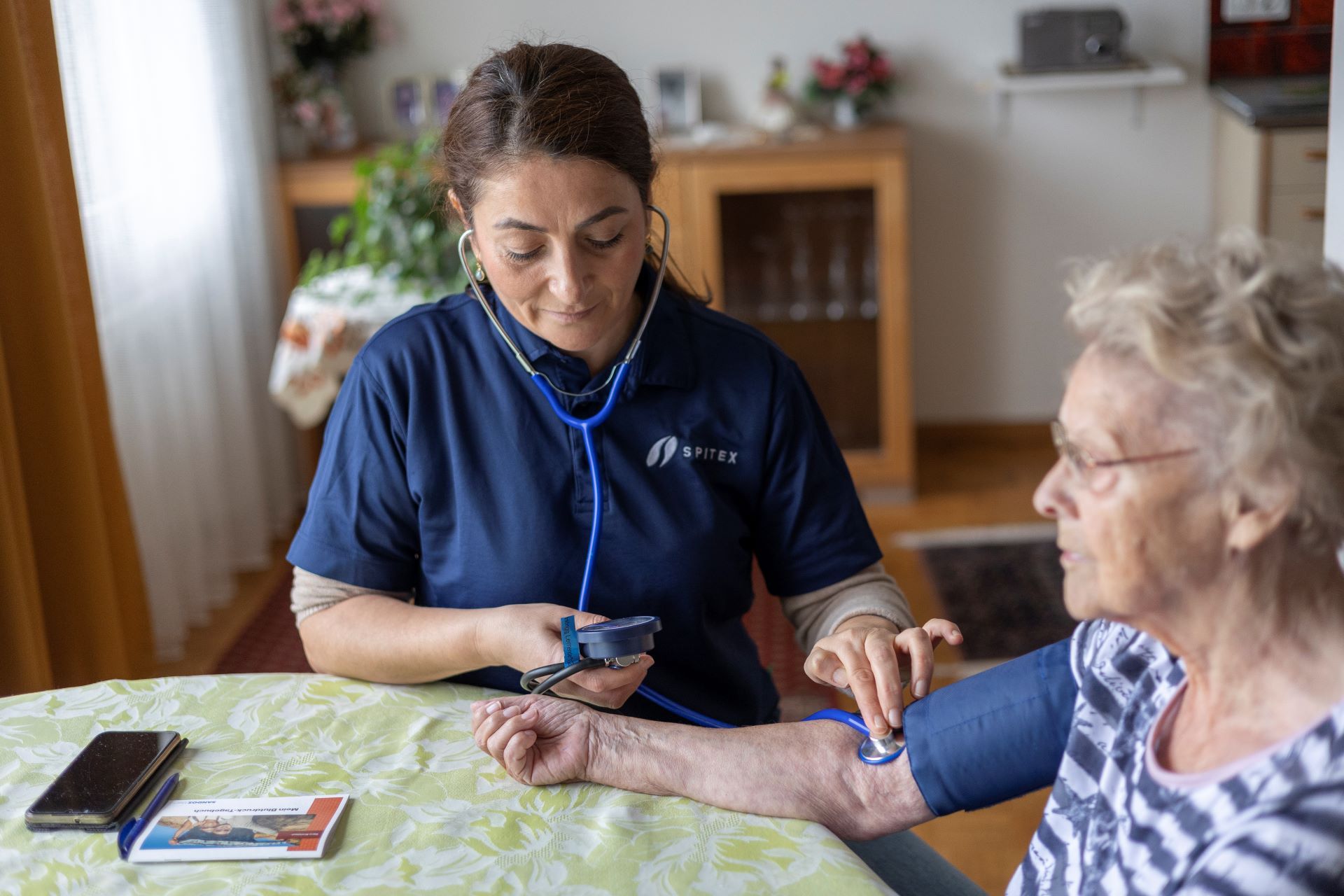 A carer assisting an elderly woman in her home. 