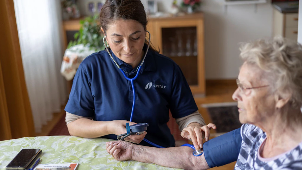 A carer assisting an elderly woman in her home. 