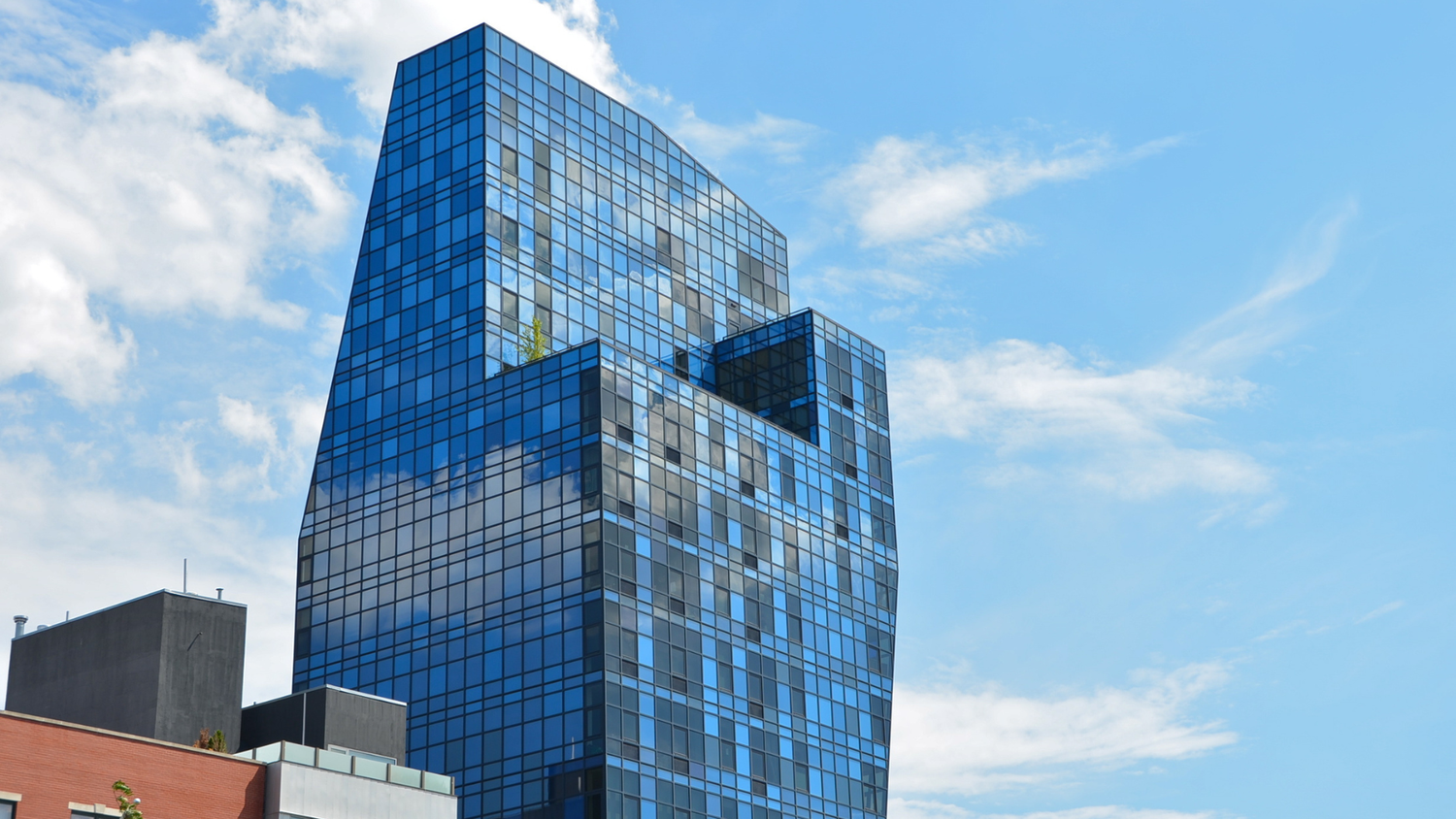 Blue glass residential building called The Blue Condominium at 105 Norfolk Street, Lower East Side, Manhattan, New York, viewed under a clear sky.