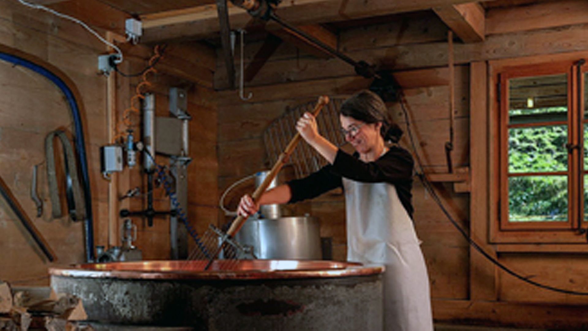 Woman making cheese with a traditional cheese vat