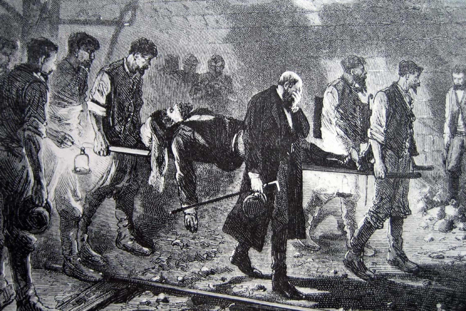 Engraving showing miners carrying a man lying on a stretcher, accompanied by a man in a black coat holding a lantern, inside a tunnel.