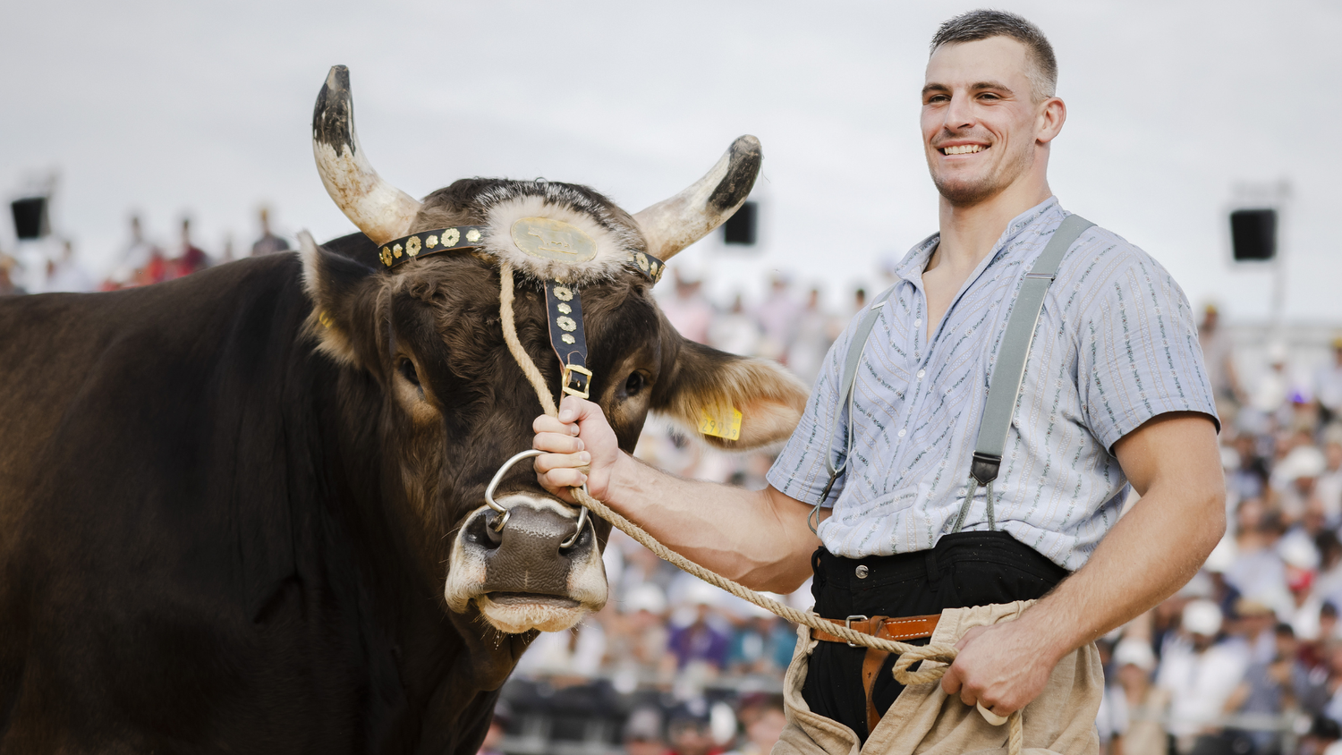 Samuel Giger, con atuendo tradicional, sostiene al toro «Harald» tras una victoria en el Kilchberger Schwinget de 2021.