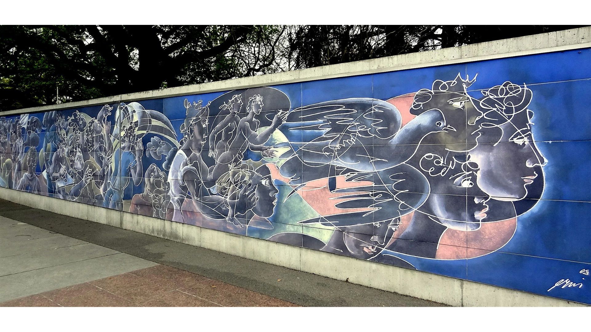 Fresco en azulejos azules de Hans Erni “Panta Rhei”: rostros y siluetas estilizadas en líneas blancas sobre fondo azul. 