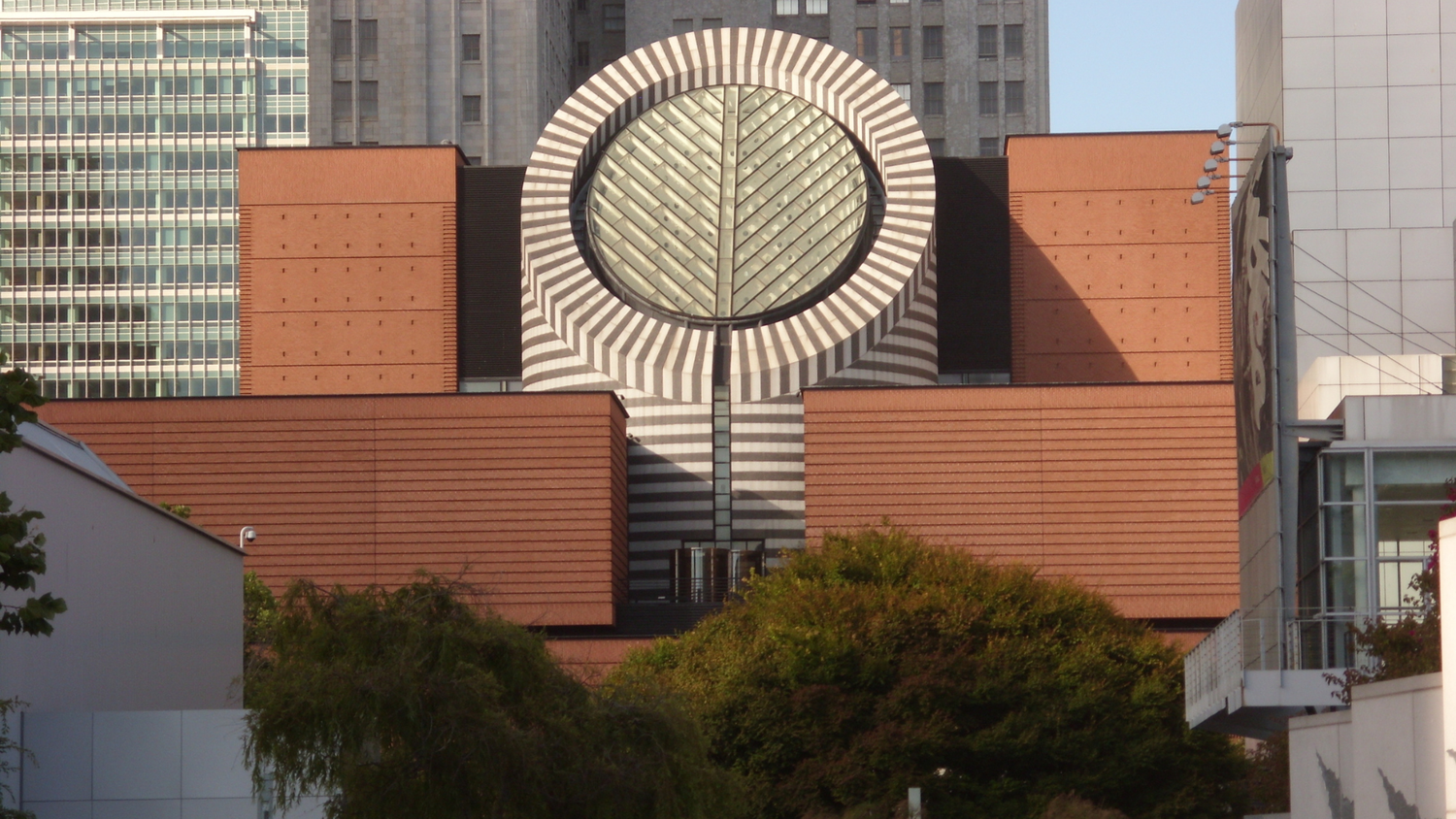 Fachada del Museo de Arte Moderno de San Francisco, edificio moderno de ladrillo rojo con gran estructura circular acristalada.