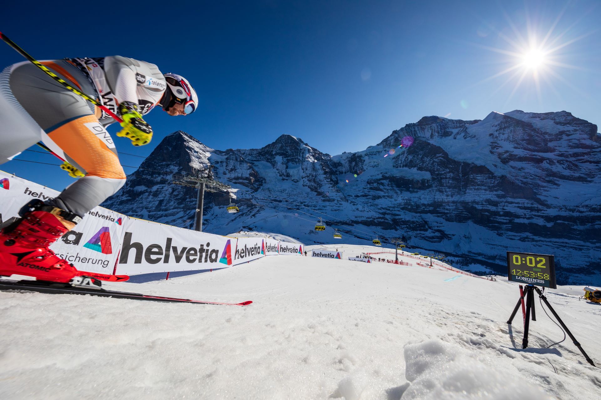 Skieur sur la piste du Lauberhorn avec vue panoramique sur les Alpes.