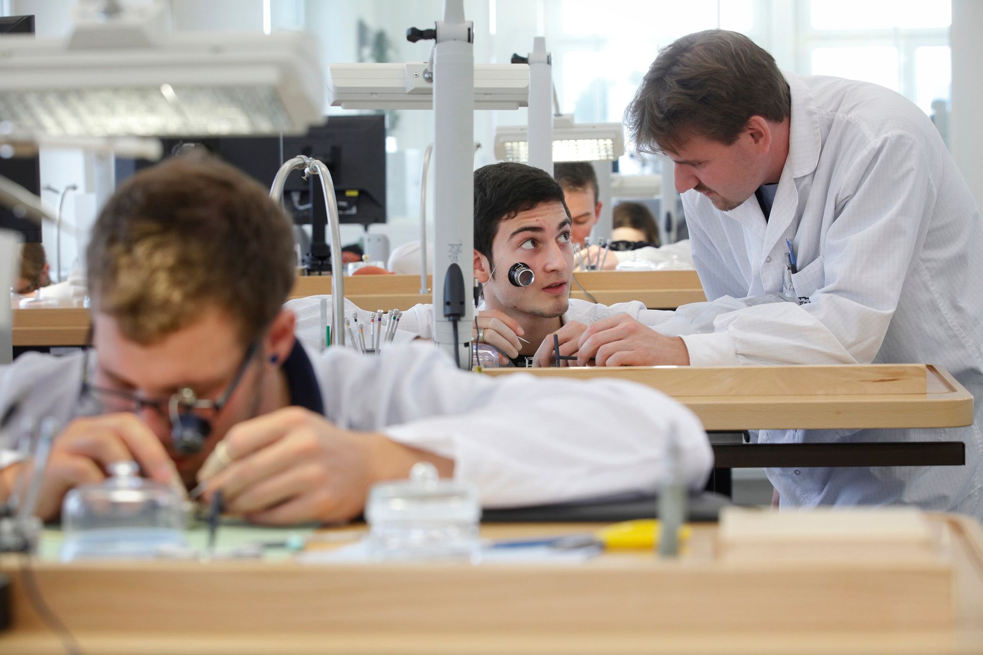 Alcuni apprendisti orologiai in una manifattura di orologi.