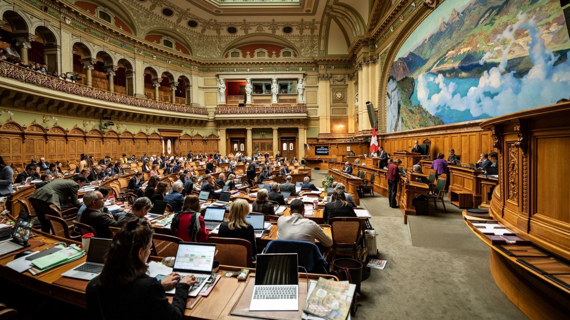 Sessione nella sala del Consiglio Nazionale con vista sulla stanza e l'affresco di Charles Giron.
