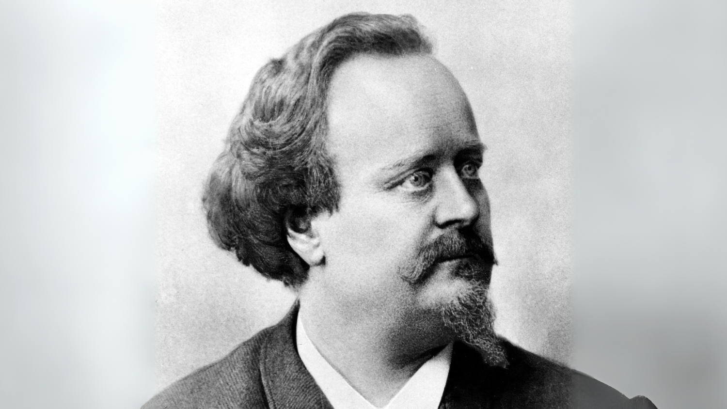 Ritratto in bianco e nero di Georg Wander, inventore e creatore di Ovomaltine, con barba e capelli ondulati, che guarda verso destra.