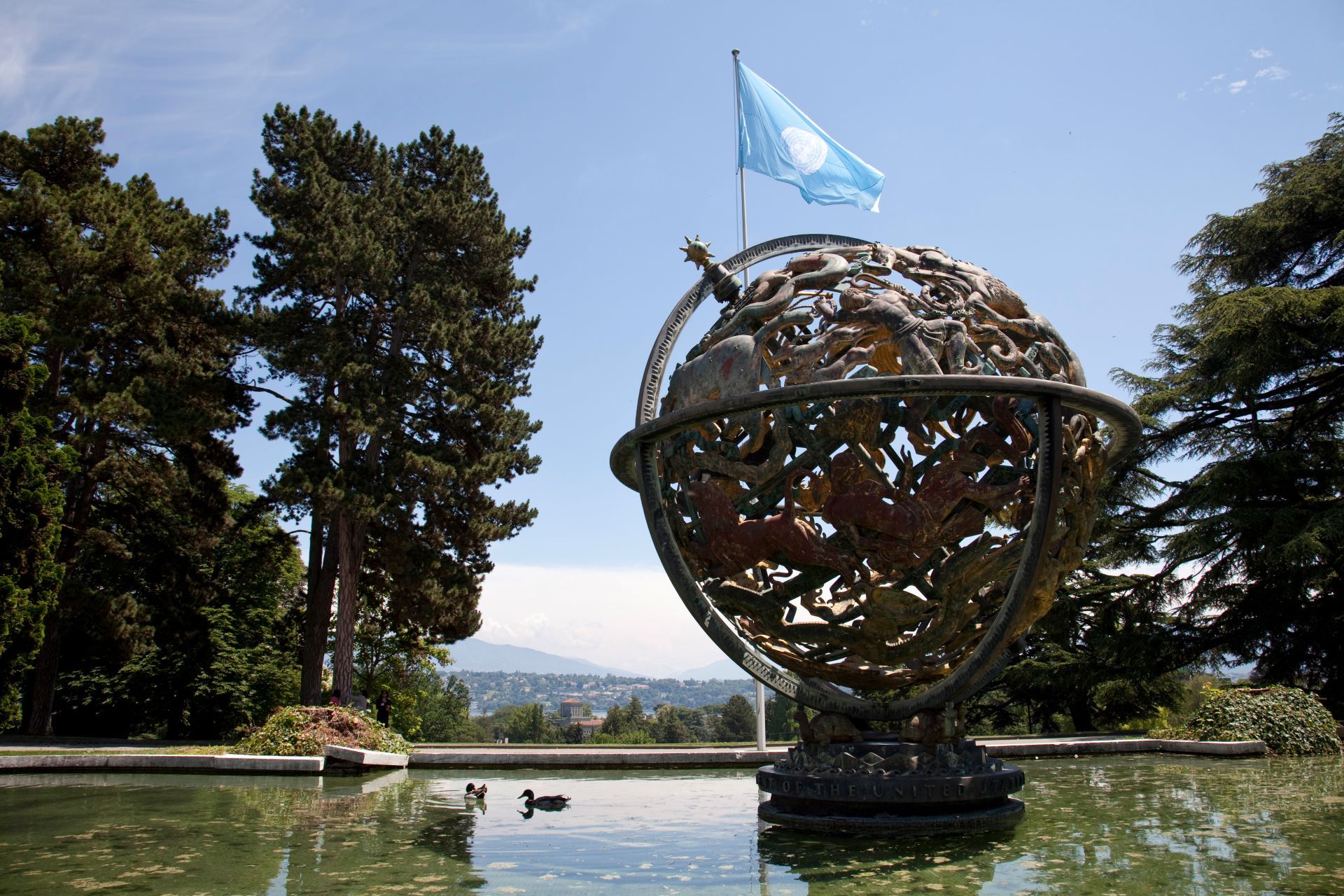 ジュネーヴにある国連の建物と池に浮かぶ地球儀のモニュメント