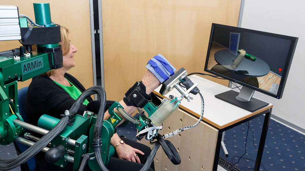 画面によって支援される治療ロボットを腕で使用する女性。