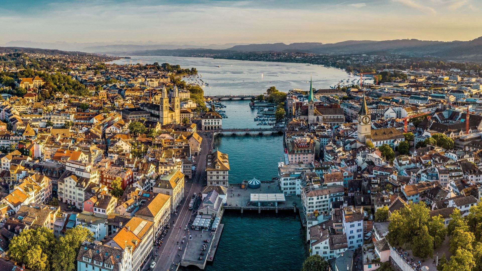 A cidade de Zurique à frente do Lago de Zurique e dos Alpes.