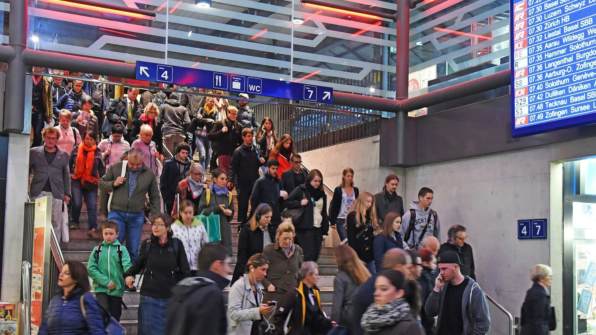Multidão de pessoas descendo as escadas da estação.