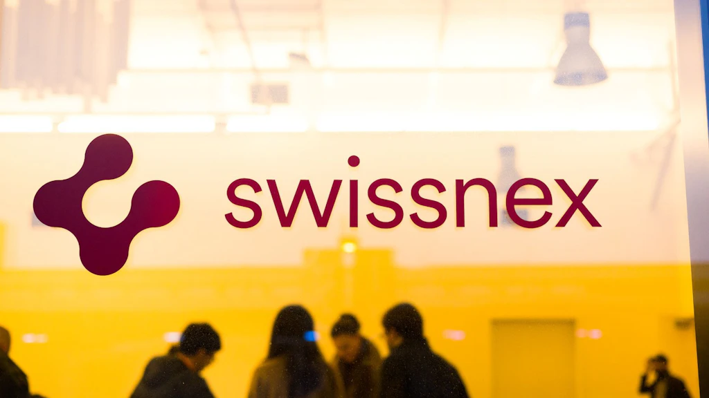 Стеклянная дверь офиса Swissnex и люди, занятые обсуждением, на заднем плане